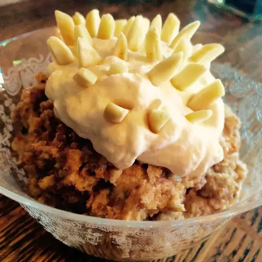 Serbian wheat pudding with whipped cream on a top